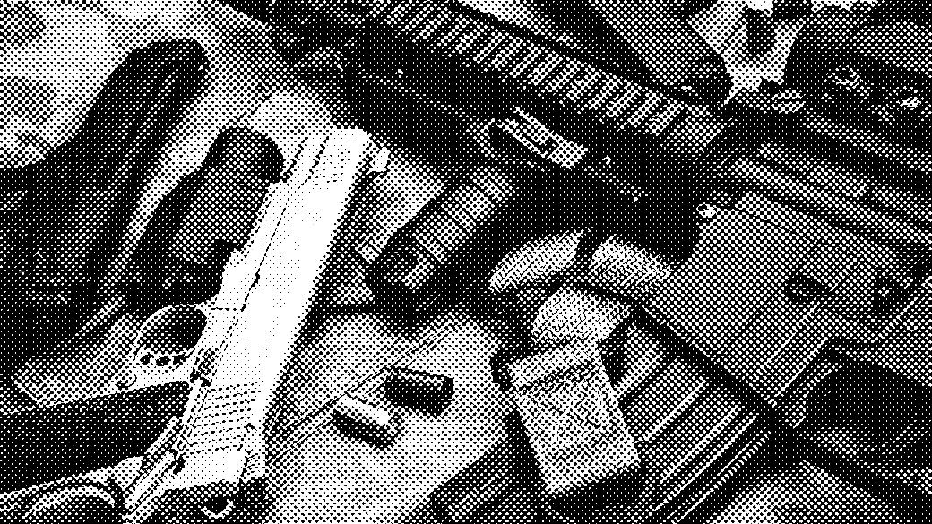 Close-up image of various firearms and ammunition placed on a camouflage-patterned surface.